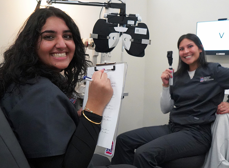 two students sitting in exam chairs