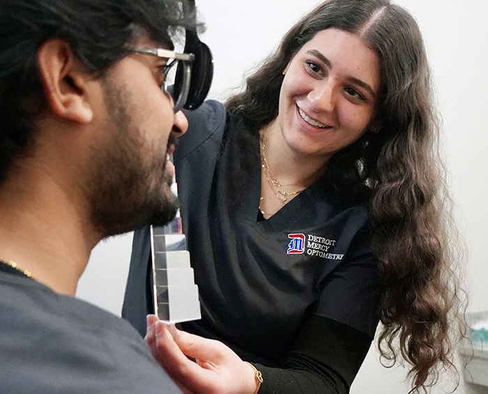 two student performing eye exam