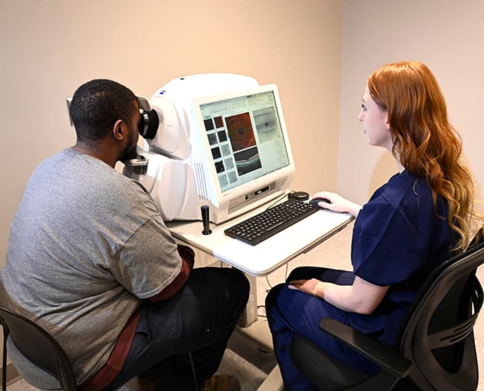 student using angioplex machine on patient